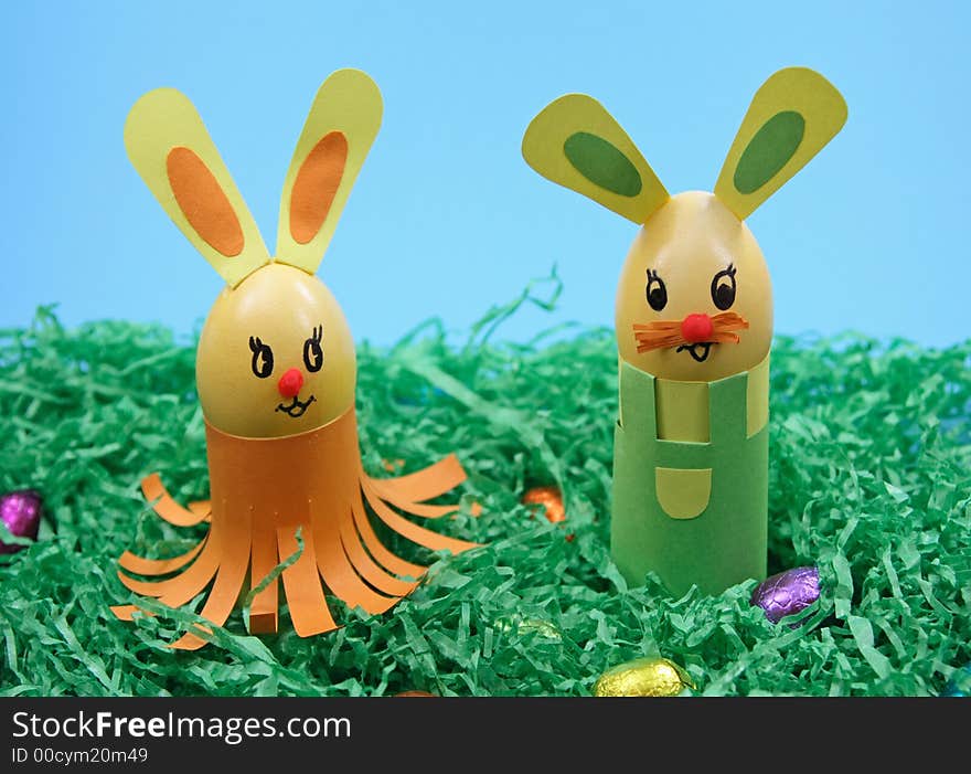 Two rabbits  in grass on  blue background