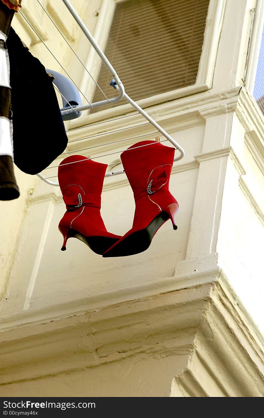 The boots are dried on a cord behind a window