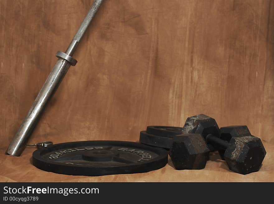 Free weights on ground with brown background. Free weights on ground with brown background