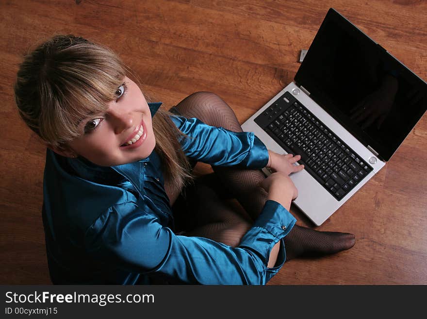 Smiling beautiful girl sitting on floor with laptop. Smiling beautiful girl sitting on floor with laptop.