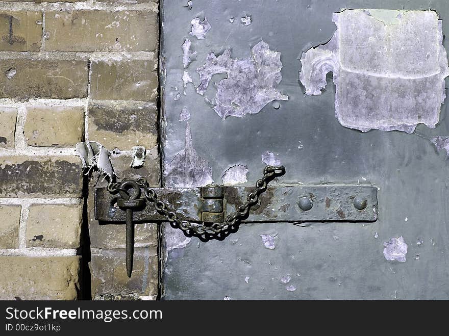 A hasp and staple on an old warehouse door.