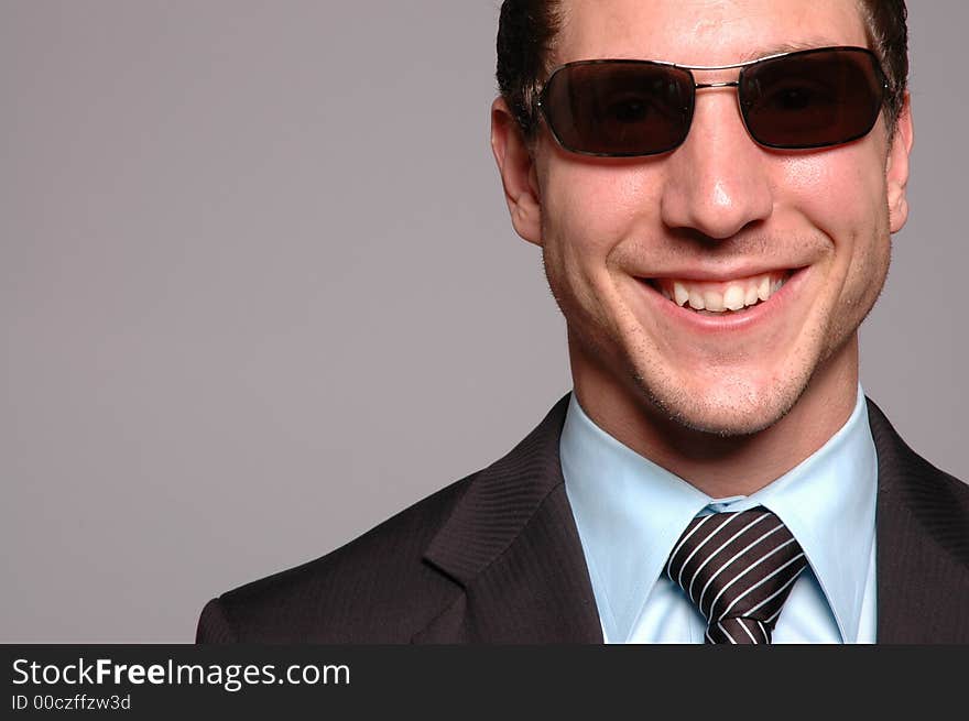 A businessman is smiling against grey background. A businessman is smiling against grey background