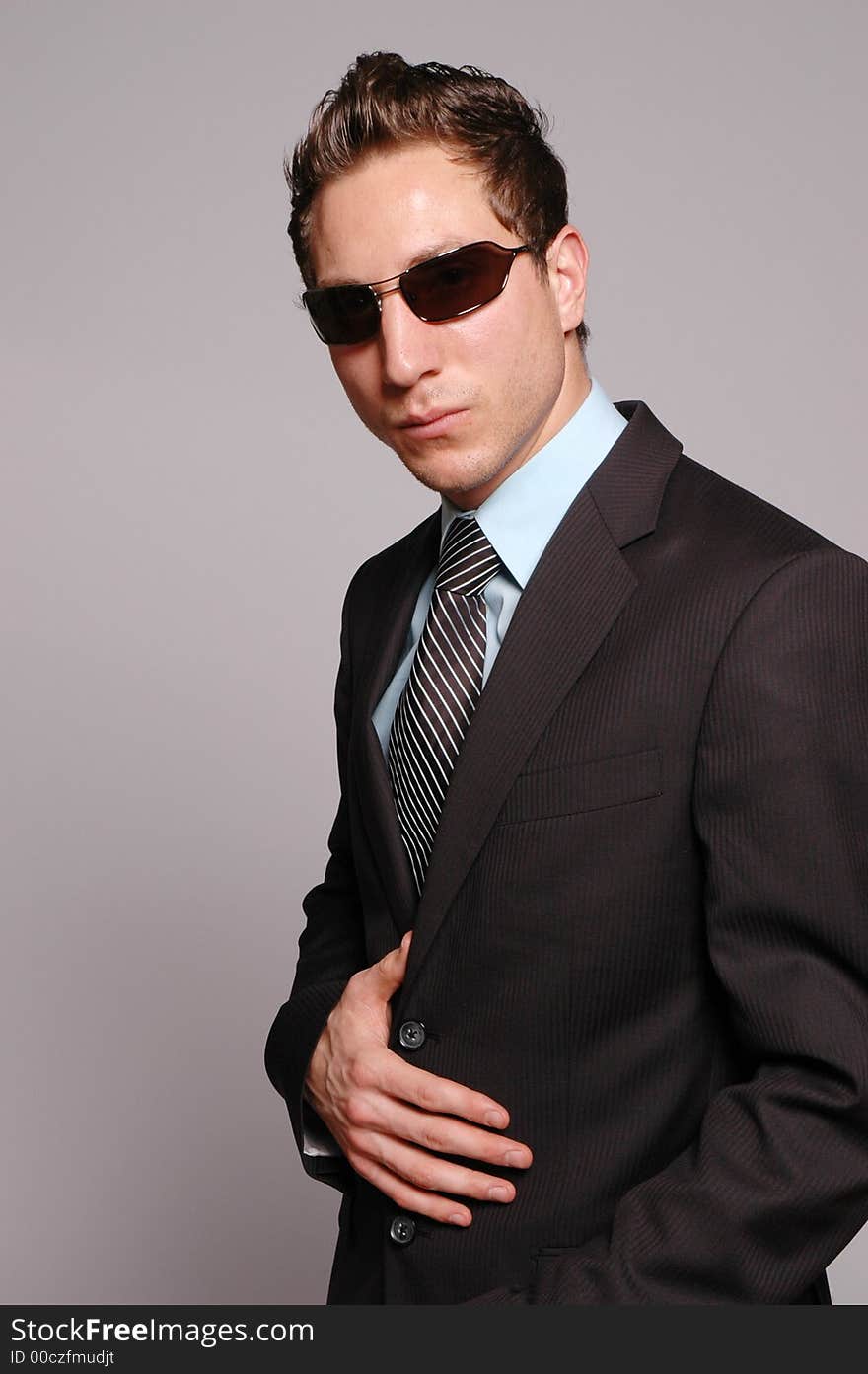 A businessman is posing against gray background. A businessman is posing against gray background