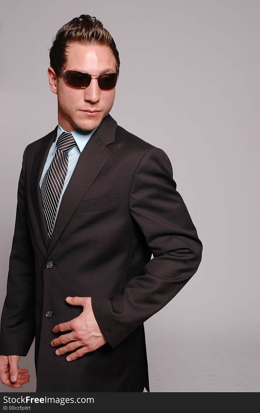 A businessman is posing against gray background. A businessman is posing against gray background