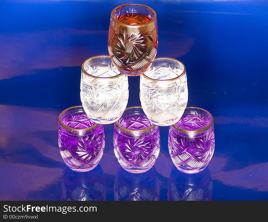 Glass pyramide of  red, white and blue drinks on blue background. Glass pyramide of  red, white and blue drinks on blue background