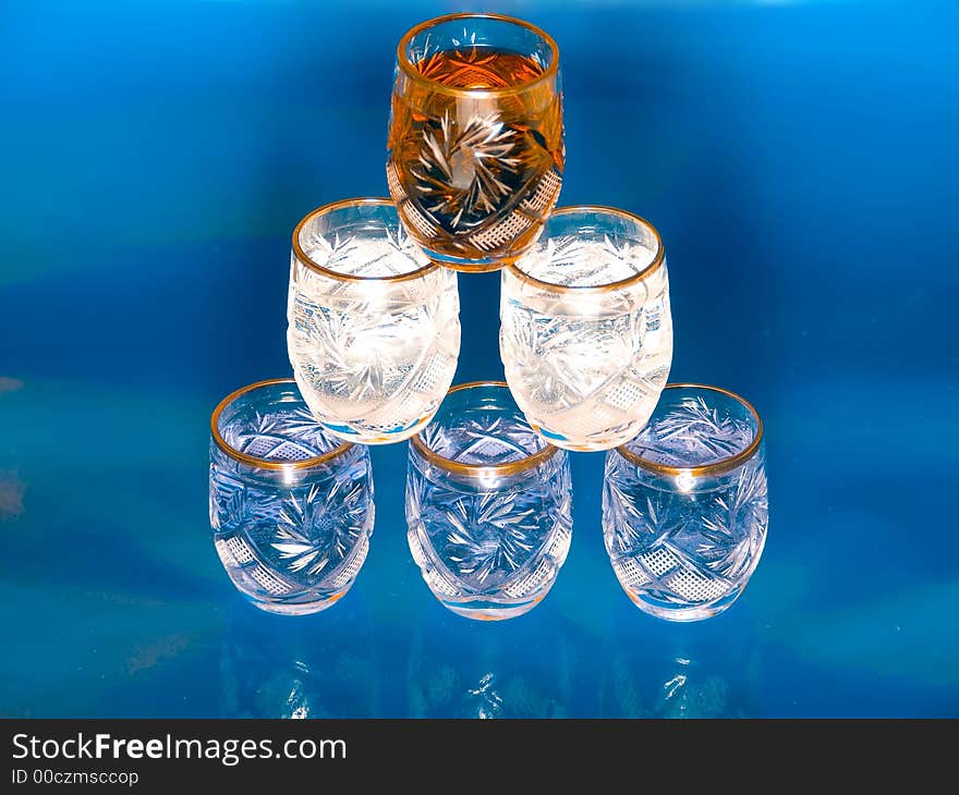 Glass pyramide of red, white and blue drinks on blue background. Glass pyramide of red, white and blue drinks on blue background