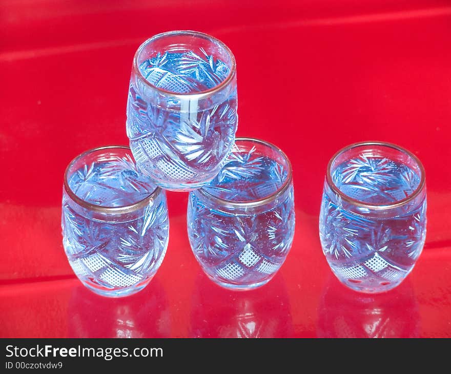 Blue pyramid of glasses on red background. Blue pyramid of glasses on red background