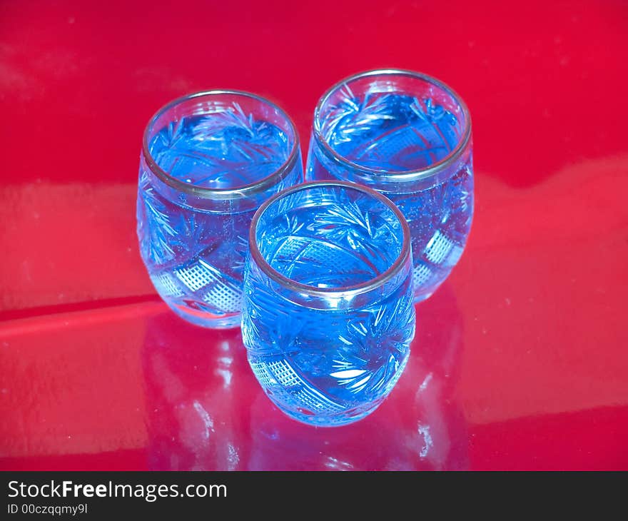 Several blue glasses on red background. Several blue glasses on red background