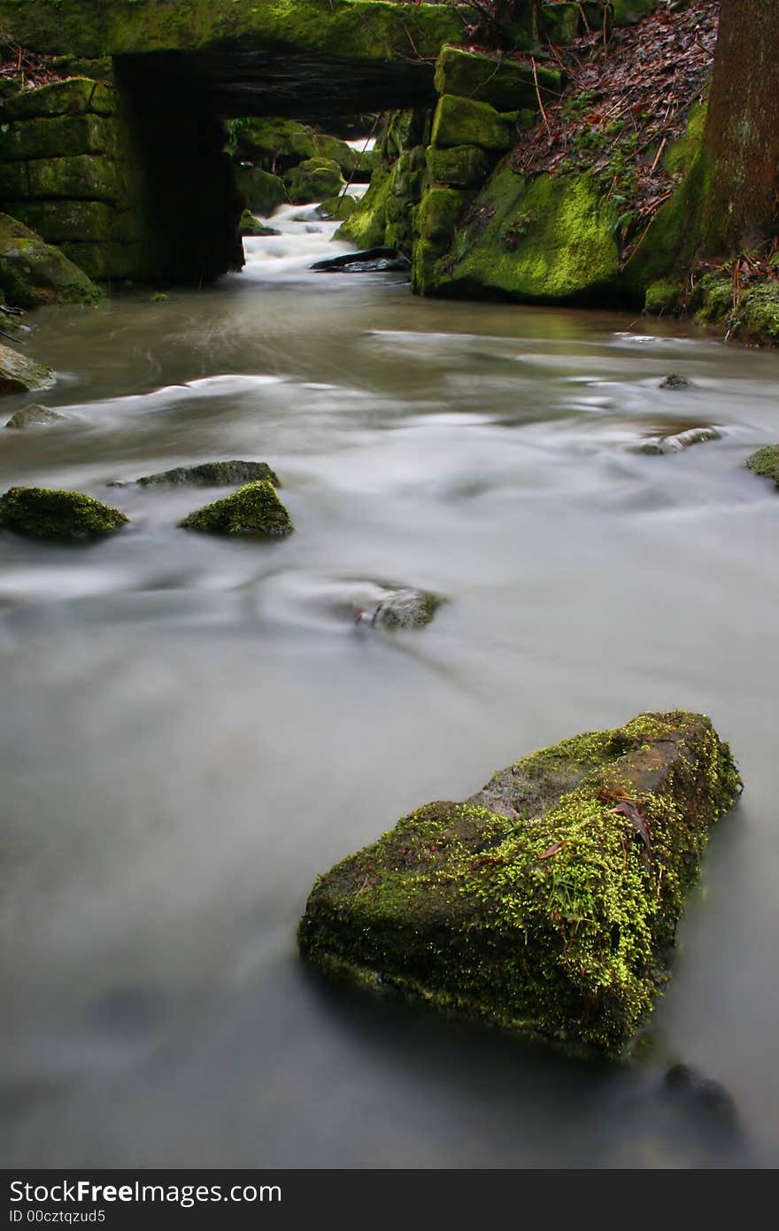 Creek with the bridge and some stones