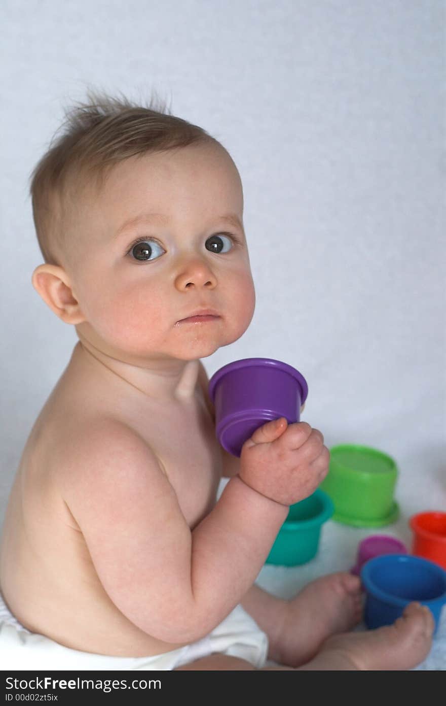 Image of adorable baby playing with stacking cups. Image of adorable baby playing with stacking cups