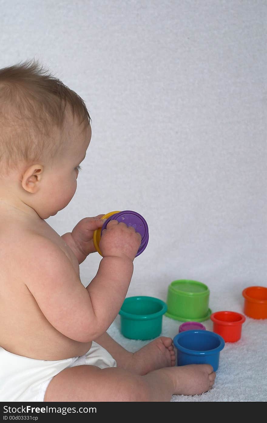 Image of adorable baby playing with stacking cups. Image of adorable baby playing with stacking cups