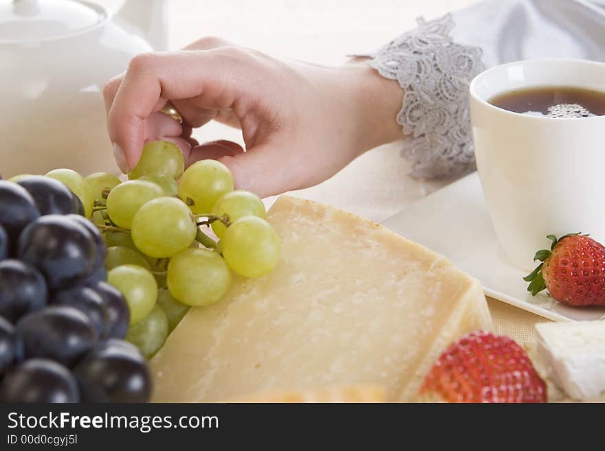 A woman taking a white grape