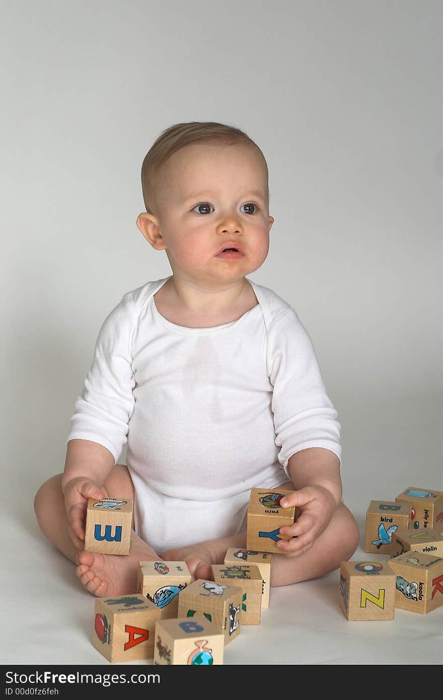 Image of cute baby playing with alphabet blocks