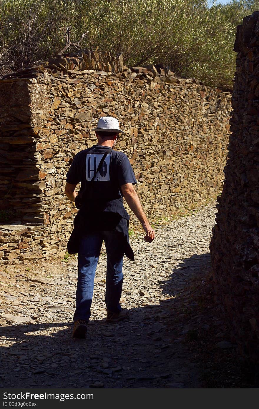 Tourist walking down a narrow mediterranean street. Tourist walking down a narrow mediterranean street