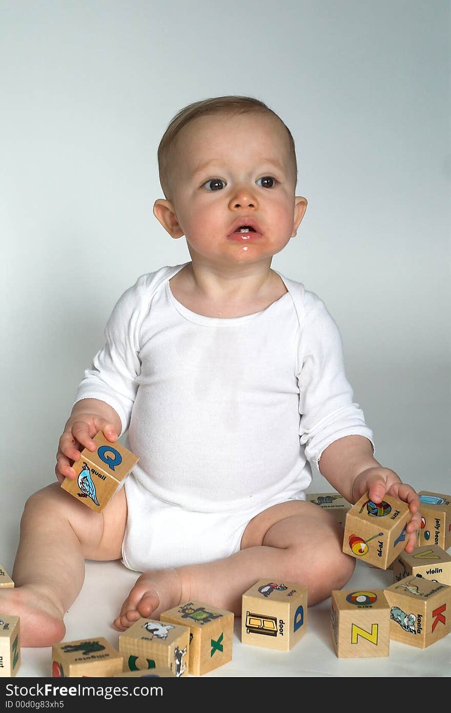 Image of cute baby playing with alphabet blocks