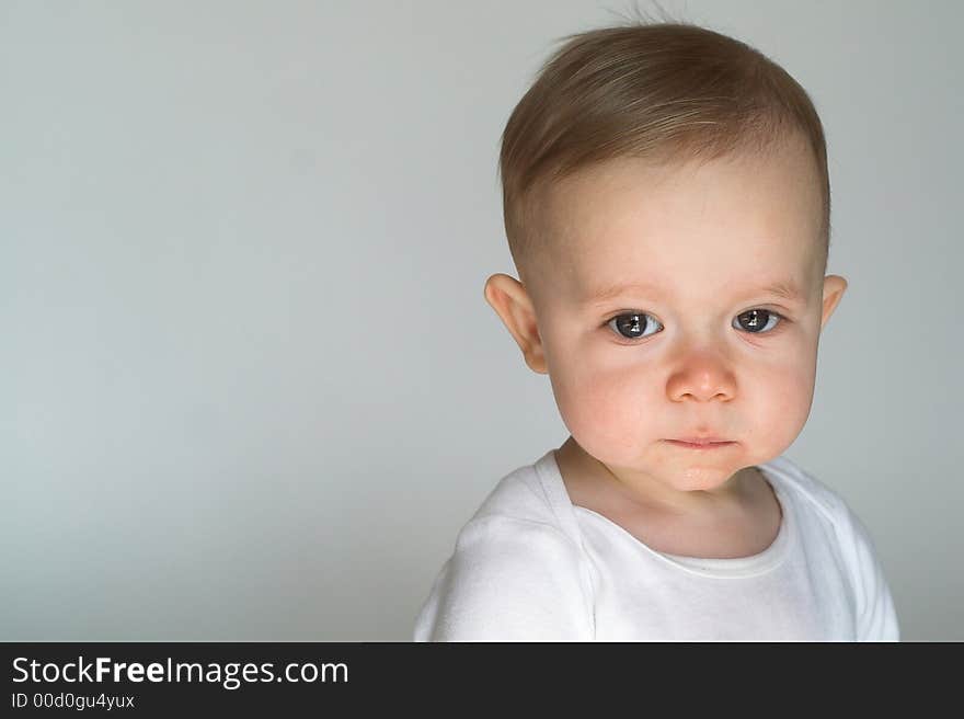 Image of beautiful 10 month old baby boy sitting in front of a white background. Image of beautiful 10 month old baby boy sitting in front of a white background