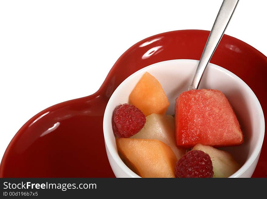 Healthy bowl of fresh fruit on a red heart shaped dish. Healthy bowl of fresh fruit on a red heart shaped dish