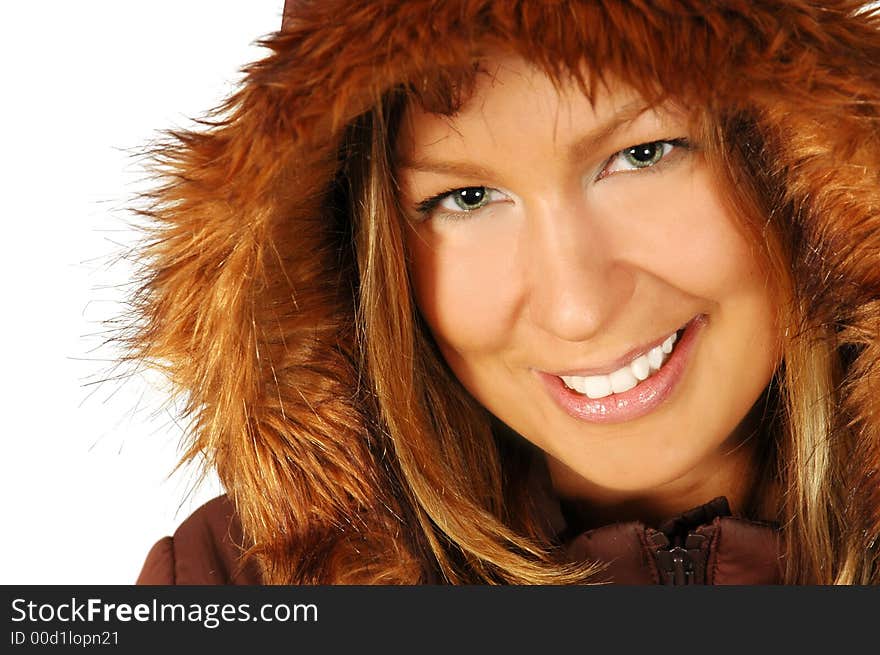 Smiling brunette wearing a winter jacket, with a fur lined hood, isolated against a white background. Smiling brunette wearing a winter jacket, with a fur lined hood, isolated against a white background.