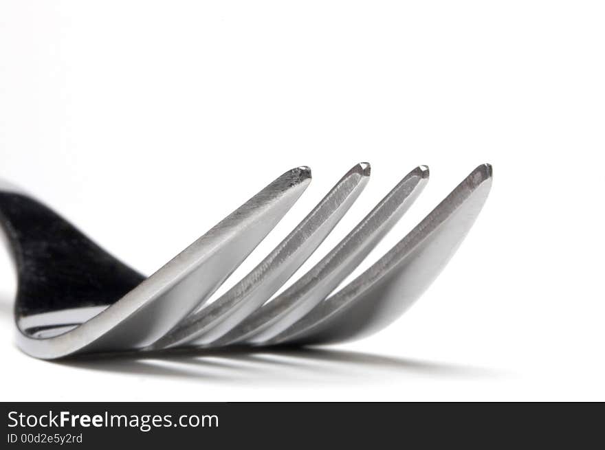 A fork in extreme closeup over a white background