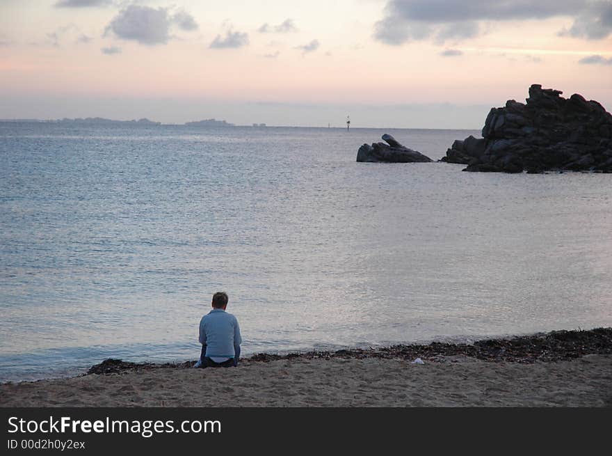 Woman sitting in full relax in front of sunset on the sea