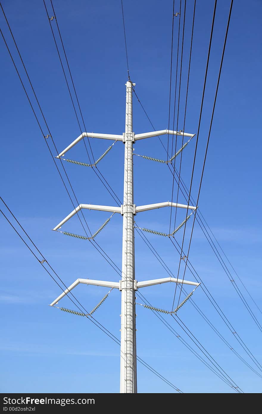 White high voltage electricity pylon and power lines against the blue sky. White high voltage electricity pylon and power lines against the blue sky.