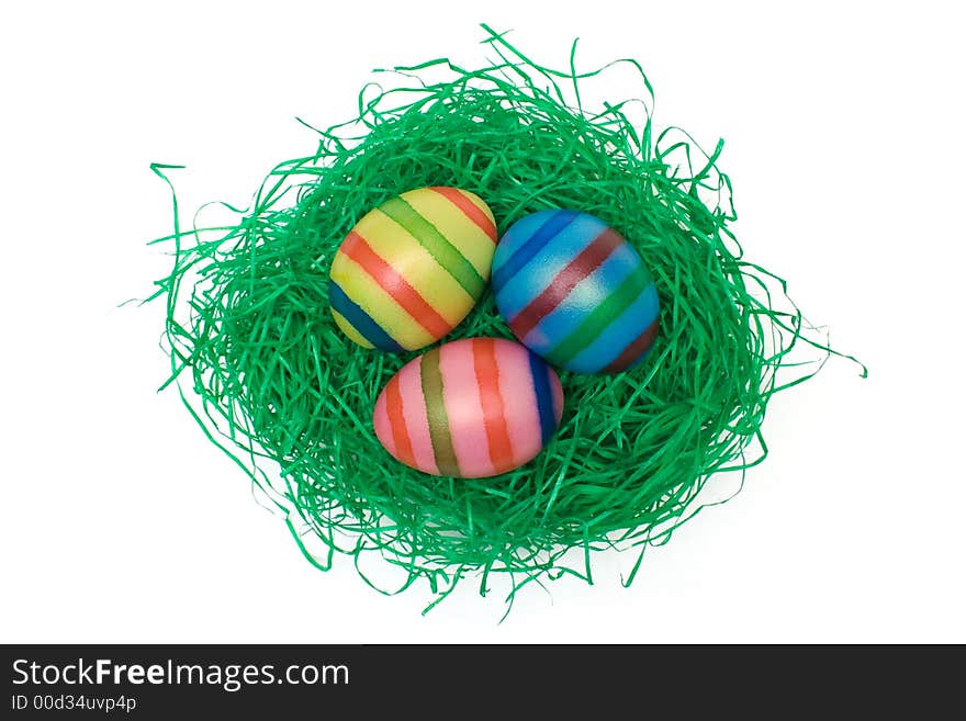 Colored eggs on artificial grass. Isolated on a white background. Colored eggs on artificial grass. Isolated on a white background.