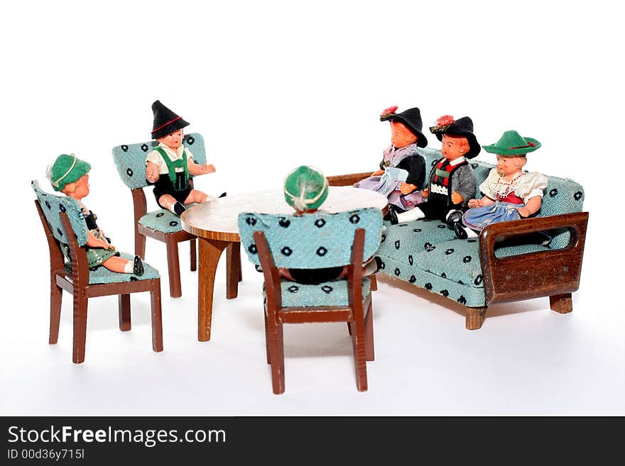 6 dolls in traditional European (I think they are Austrian but not sure) dresses sitting on chairs and couch round a table (old hand made furniture). 6 dolls in traditional European (I think they are Austrian but not sure) dresses sitting on chairs and couch round a table (old hand made furniture)