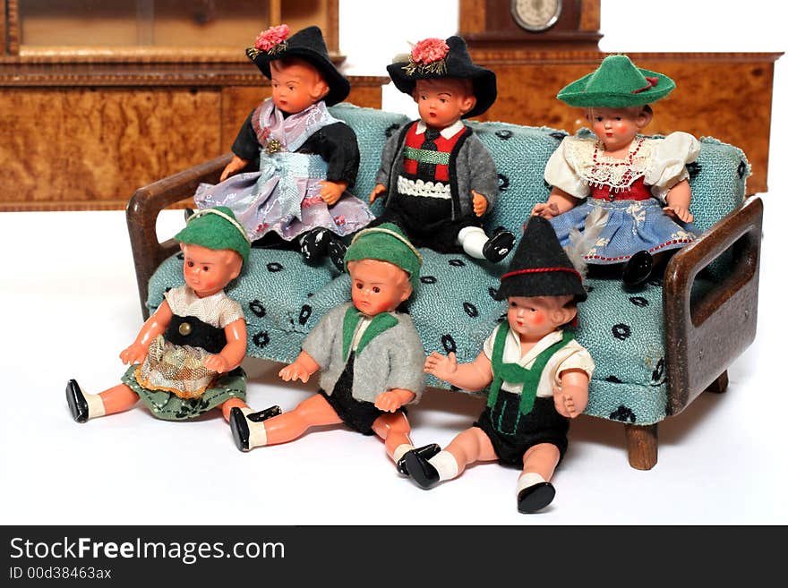 6 dolls in traditional European (I think they are Austrian but not sure) dresses sitting on a couch (old hand made furniture) with racks on the background. 6 dolls in traditional European (I think they are Austrian but not sure) dresses sitting on a couch (old hand made furniture) with racks on the background.