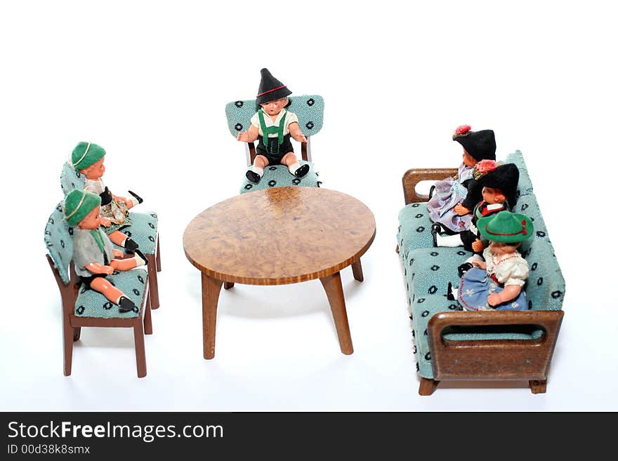 6 dolls in traditional European (I think they are Austrian but not sure) dresses sitting on chairs and couch round a table (old hand made furniture). 6 dolls in traditional European (I think they are Austrian but not sure) dresses sitting on chairs and couch round a table (old hand made furniture).