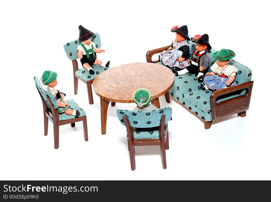 6 dolls in traditional European (I think they are Austrian but not sure) dresses sitting on chairs and couch round a table (old hand made furniture). 6 dolls in traditional European (I think they are Austrian but not sure) dresses sitting on chairs and couch round a table (old hand made furniture).