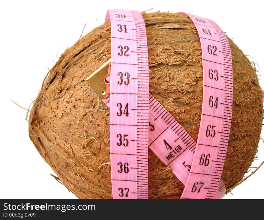 Coconut with pink tape measure over white background (concept of health, diet)