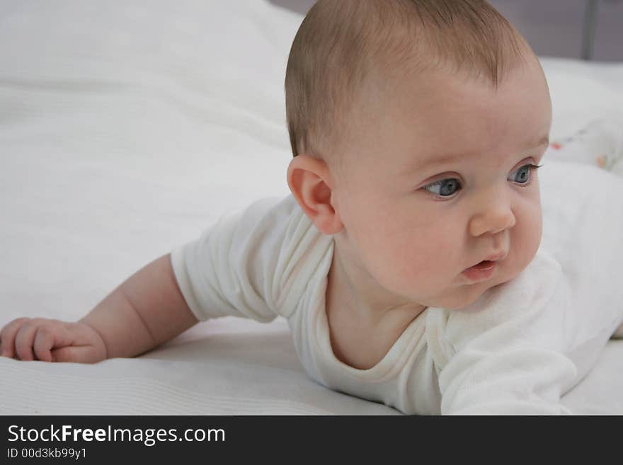 Blue eyed baby in bed.