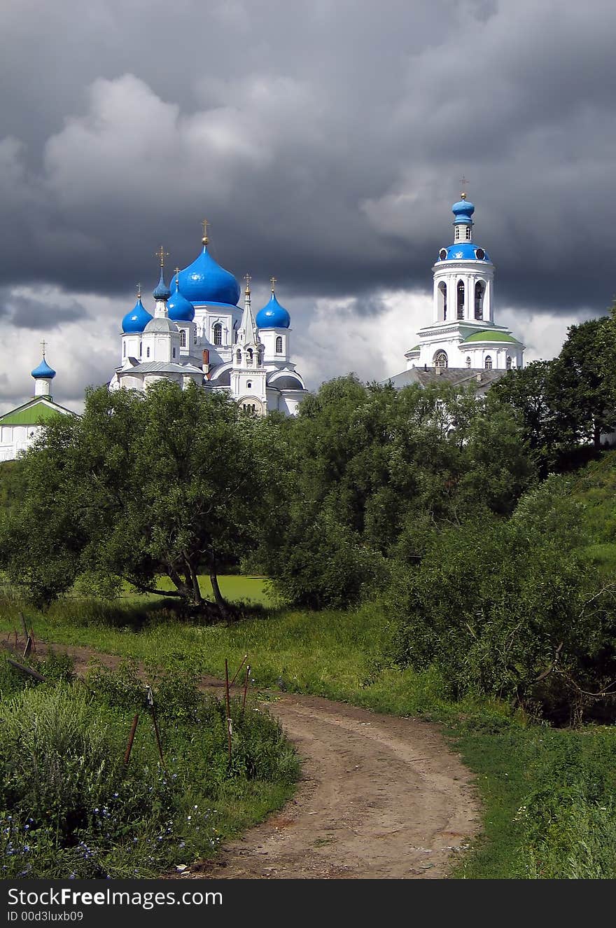 Summer view of road to the Temple in nunnery at the backgound thunderstorm cloudscape. (Bogolyubovo, Vladimir region, Golden Ring of Russia). Summer view of road to the Temple in nunnery at the backgound thunderstorm cloudscape. (Bogolyubovo, Vladimir region, Golden Ring of Russia).