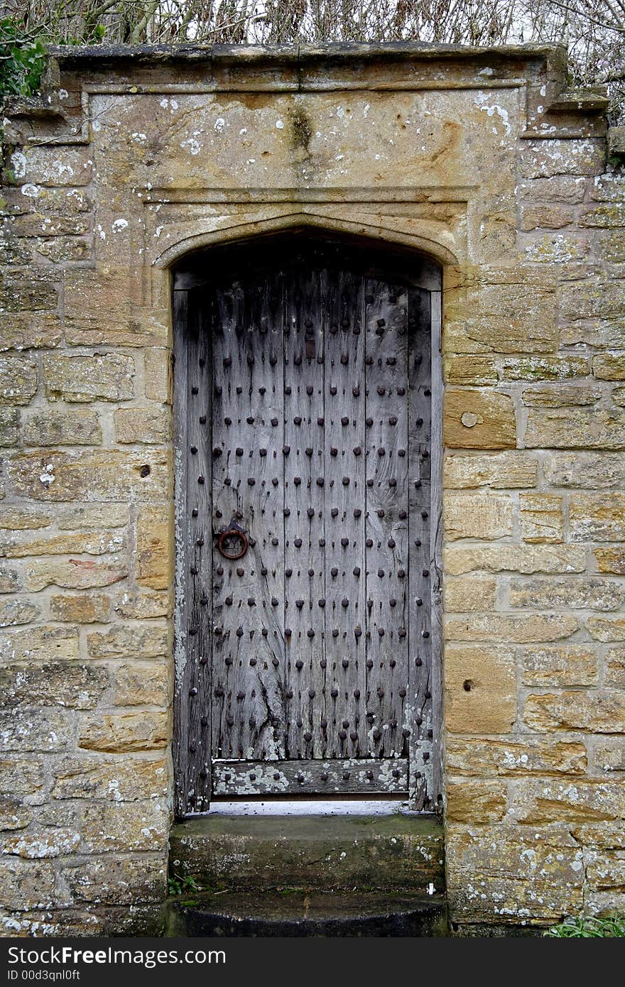 Ancient Wooden Door through a natural stone Wall. Ancient Wooden Door through a natural stone Wall