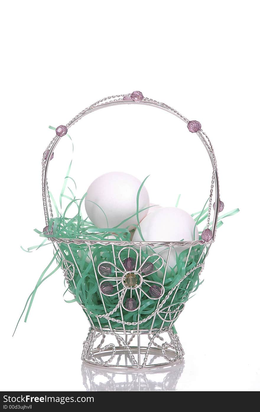 A small, dainty silver Easter basket filled with eggs. White background. A small, dainty silver Easter basket filled with eggs. White background.