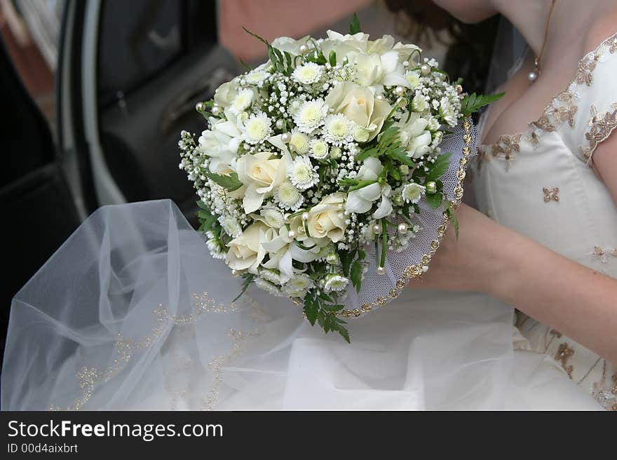 Wedding bouquet in a hand of the bride in wedding car. Wedding bouquet in a hand of the bride in wedding car