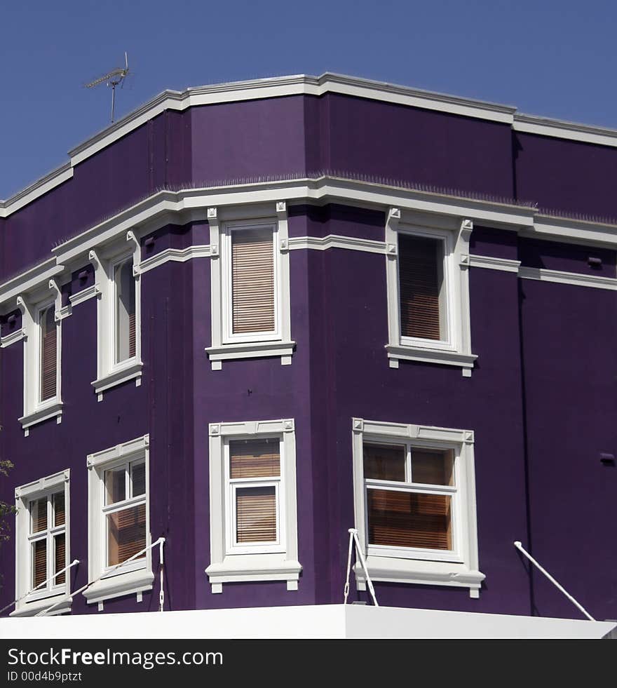 Purple, Violet Facade With White Windows, Urban Corner Building. Purple, Violet Facade With White Windows, Urban Corner Building