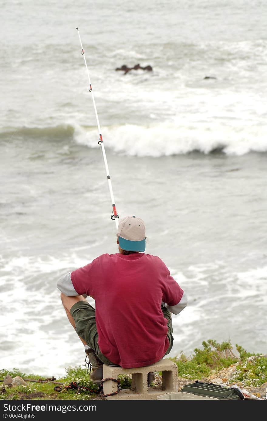 A man fishing in the surf along the California coast