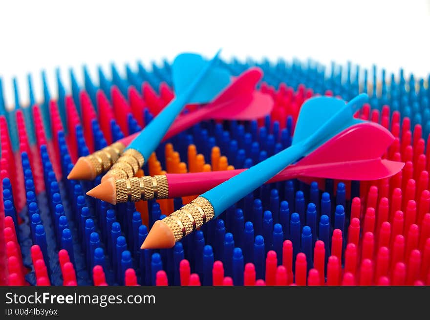 Isolated photo of red and blue toy darts resting on the dartboard, creating the sense of completion, resting. Isolated photo of red and blue toy darts resting on the dartboard, creating the sense of completion, resting.