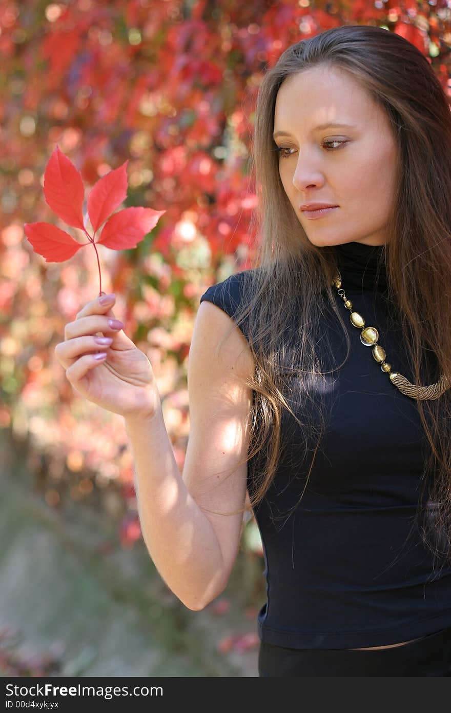 Girl holding a red leaf. Girl holding a red leaf