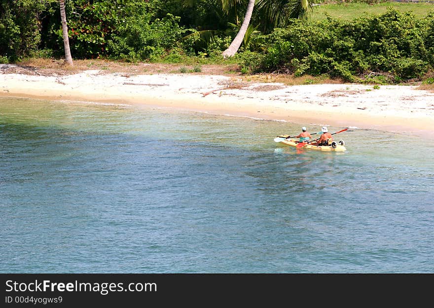 A couple in an inflated raft exploring the coast of a bay. A couple in an inflated raft exploring the coast of a bay