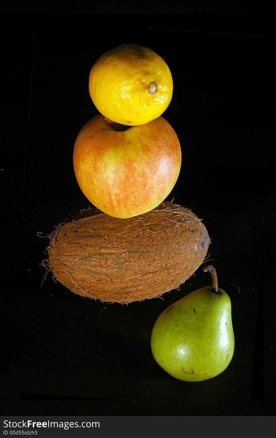 Fruits on black - pear, apple, lemon, coconut