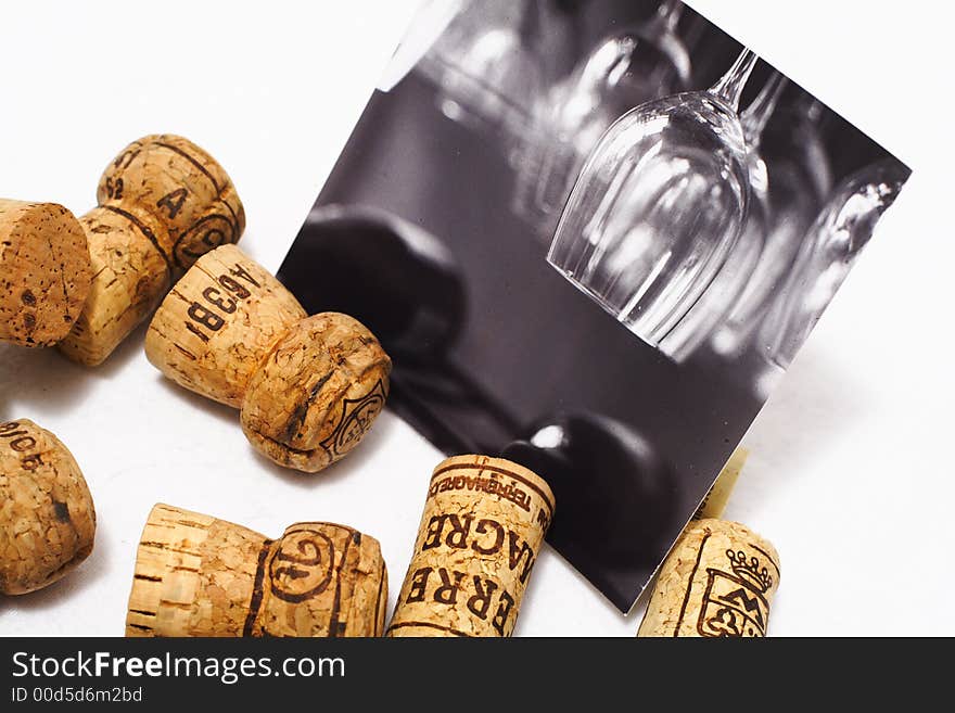 A black and white picture of wine glasses on display with corks. A black and white picture of wine glasses on display with corks