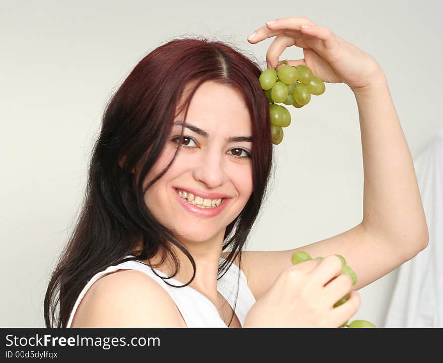 Oriental pretty girl give the grape in a hand. Oriental pretty girl give the grape in a hand