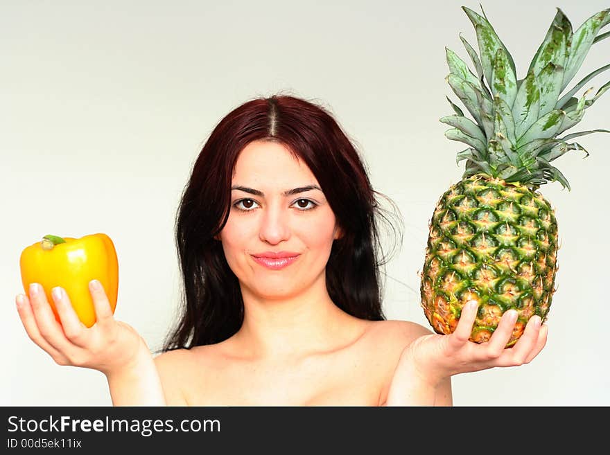 Asian pretty girl with yellow peper and pineapple in a hand. Asian pretty girl with yellow peper and pineapple in a hand