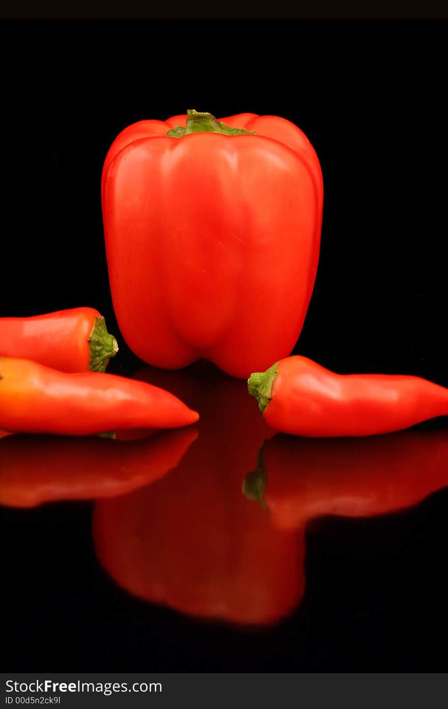 Red and Chili Peppers reflecting in a black background. Red and Chili Peppers reflecting in a black background.