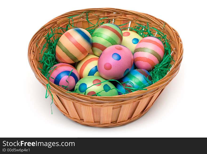 Colorful eggs on green grass in a wooden basket. Isolated on a white background. Colorful eggs on green grass in a wooden basket. Isolated on a white background.