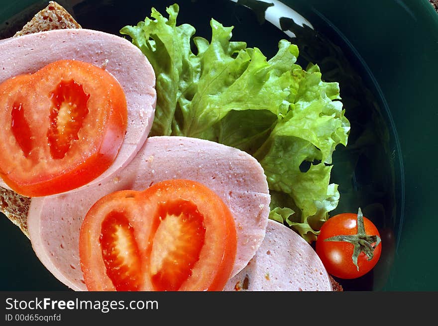 Sandwich with salami, tomatoes and green salad. Sandwich with salami, tomatoes and green salad