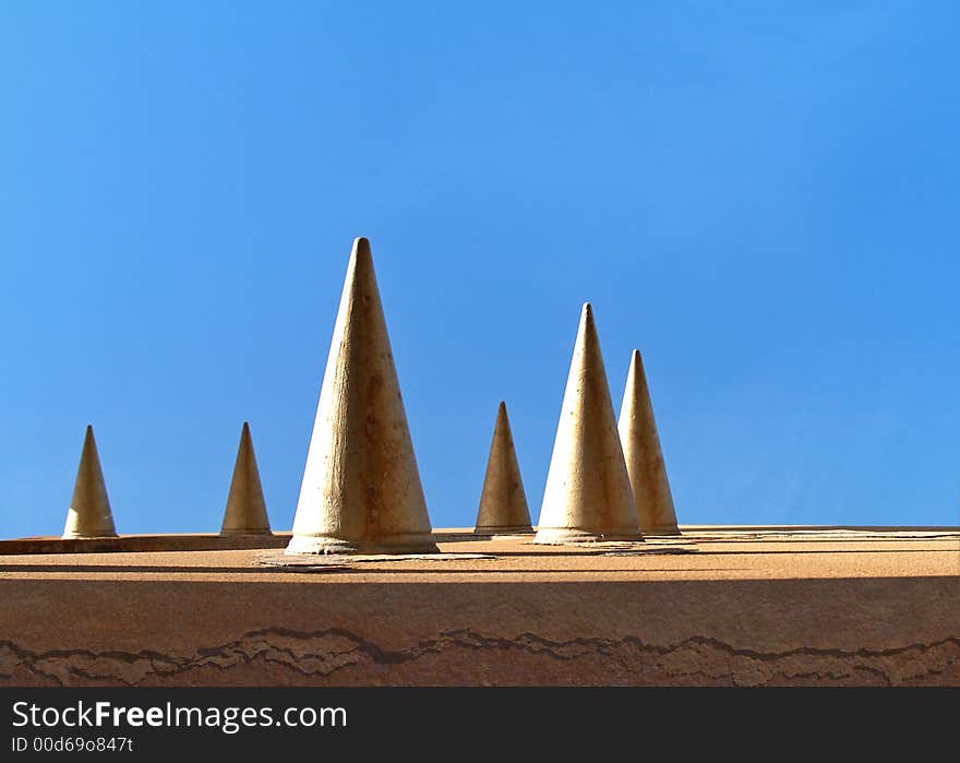 Spiked metal with rust and blue sky. Spiked metal with rust and blue sky