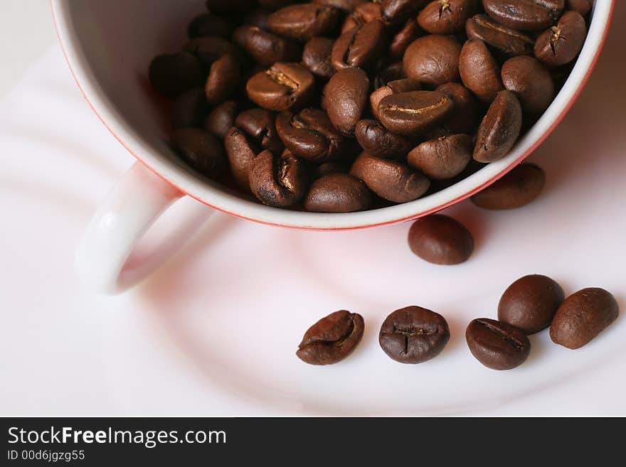 Grains of coffee in a white bowl. Macro-ring